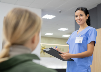 Woman in blue scrubs holding a clipboard